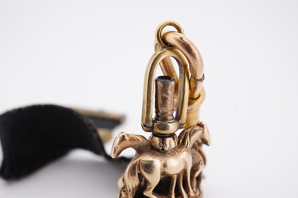 A late Victorian yellow metal overlaid and citrine set watch key fob, depicting two horses and two rams?, 30mm on a black sash suspension, together with a modern pair of 9ct gold and cultured pearl set leaf ear studs. Co